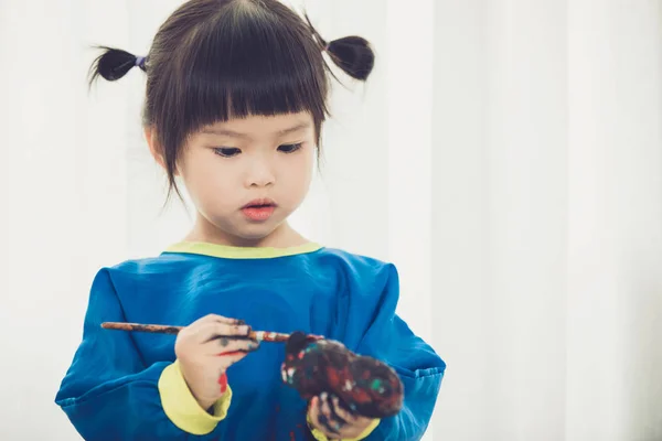 Portret van een schattig klein meisje Desinformatieraketten spelen met verf. — Stockfoto