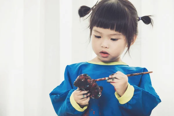 Portret van een schattig klein meisje Desinformatieraketten spelen met verf. — Stockfoto