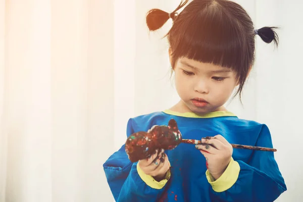 Portret van een schattig klein meisje Desinformatieraketten spelen met verf. — Stockfoto