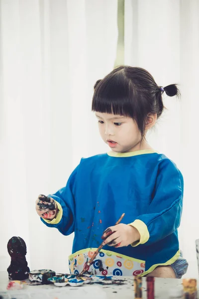 Ritratto di una ragazzina carina che gioca disordinatamente con le vernici . — Foto Stock