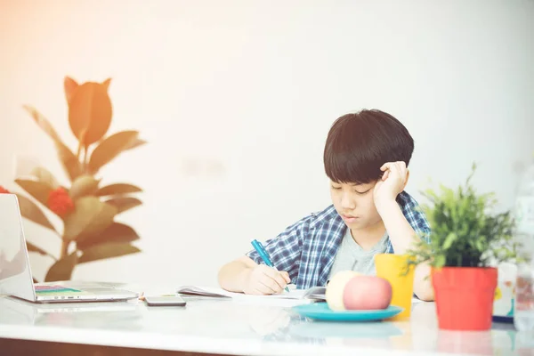 Asian Cute little boy reading book with serious face . — Stock Photo, Image