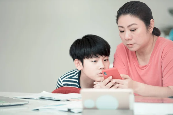 アジアの少年の家で宿題を授業の母 — ストック写真