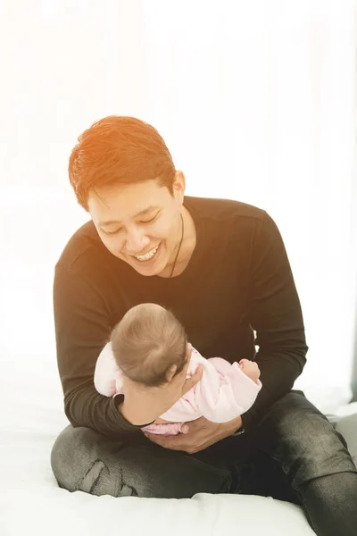 Orgulhoso asiático pai segurando seu bebê recém-nascido em casa . — Fotografia de Stock
