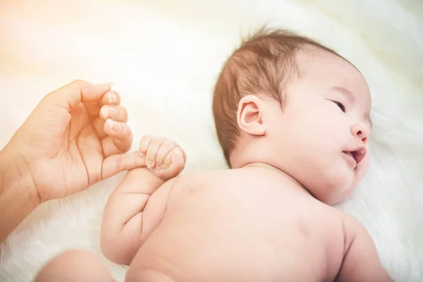 Baby som sover i sängen och handen håller hans mamma, — Stockfoto