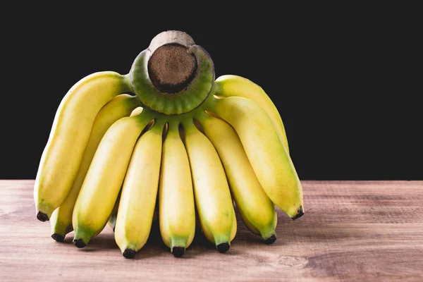 Banane mit Schatten auf Holz-Hintergrund — Stockfoto
