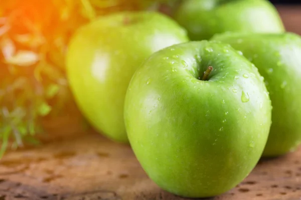 Zielone jabłuszko z kropli wody na stół z drewna — Zdjęcie stockowe