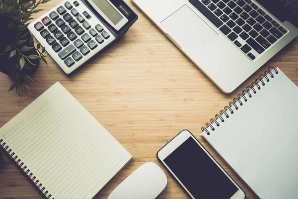 Mix of office supplies and gadgets on a wooden desk . — Stock Photo, Image