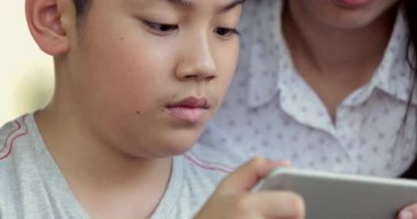 Mutlu aile anne ve oğlu mobil cep telefonuyla birlikte oyun oynarken.