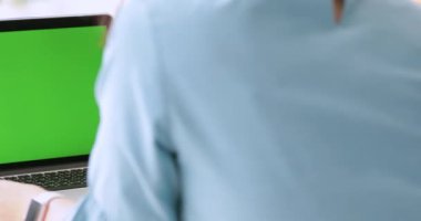 Dizüstü bilgisayar ile yeşil ekran kullanan genç Asyalı kadın.