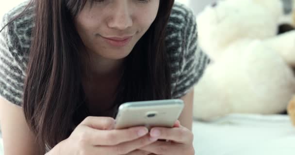 ベッドの上にスマート フォンを使用して若いアジア女性 — ストック動画