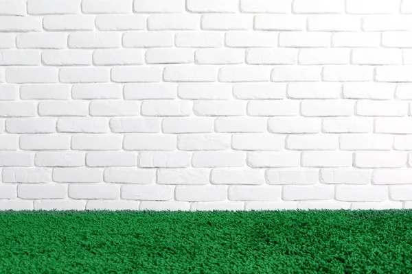 White brick wall and green carpet floor . — Stock Photo, Image