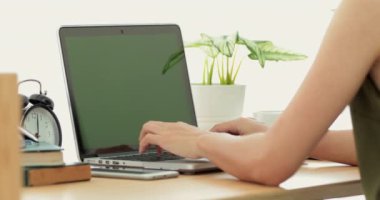 Üzerinde bir anahtar yeşil ekran ile bir dizüstü bilgisayarda yazarak bir Asyalı omuz çekim .