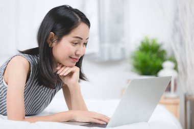 Evde dizüstü bilgisayar kullanan Asyalı kadın,
