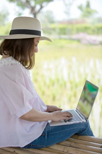 Asiatisk kvinna i leende ansikte med laptop. — Stockfoto