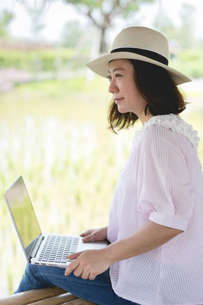 Asiatisk kvinna i leende ansikte med laptop. — Stockfoto