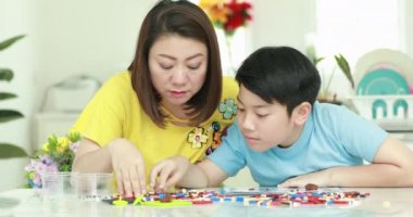 Mutlu Asya aile anne ve oğlu plastik blok birlikte oynama .
