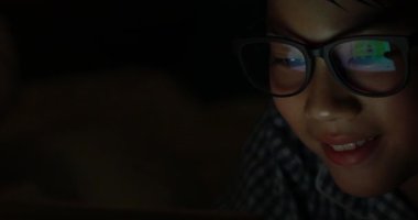 Genç çocuk bir cep telefonu veya bir yatakta smartphone ile oynamak. gece