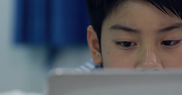 携帯電話やスマート フォン ベッドの上で遊んでアジアの若い男の子 — ストック動画