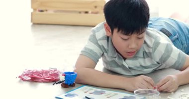 Sevimli Asya çocuk gülümsemek yüz plastik blok evde oynarken.