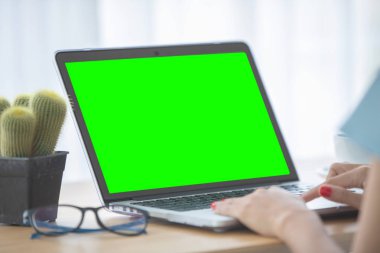 Dizüstü bilgisayar ile boş yeşil ekran kullanan bir kadın görüntüsünü mockup.