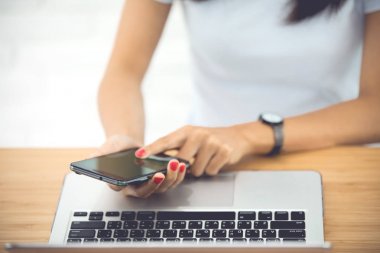 Smartphone ve dizüstü kullanarak kadın ellerini kapatın