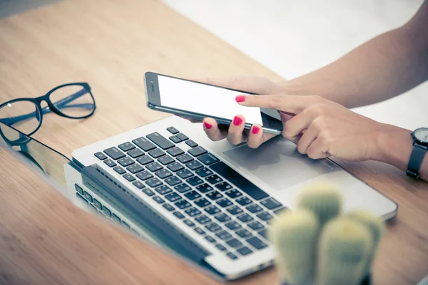 Close up woman hands using smartphone and laptop — Stock Photo, Image