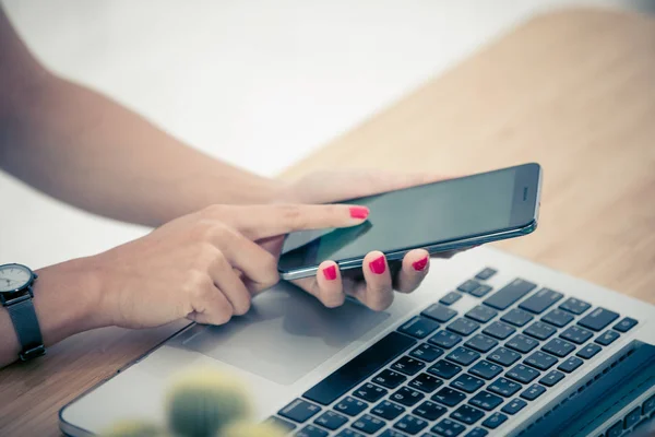 Close up woman hands using smartphone and laptop — Stock Photo, Image