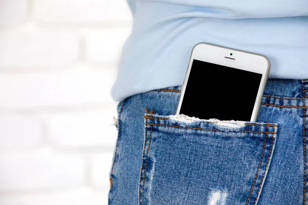 Smartphone con schermo bianco in tasca jeans . — Foto Stock