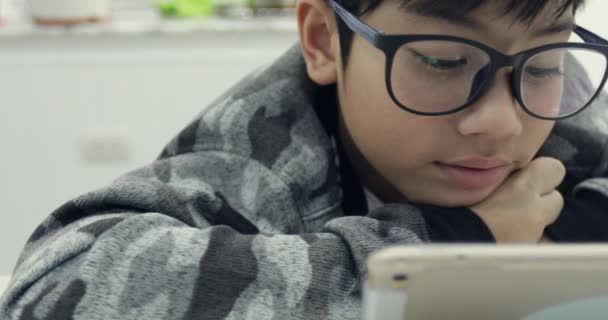 Lindo Chico Asiático Con Anteojos Uso Computadora Tableta Joven Adolescente — Vídeo de stock