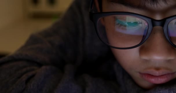 Gros plan de mignon asiatique garçon portant des lunettes de vue et à l'aide d'un ordinateur tablette, Jeune adolescent garçon jouer à des jeux sur tablette numérique  .