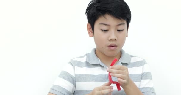 Poco Asiático Chico Comer Gelatina Sonrisa Blanco Pared Fondo — Vídeos de Stock