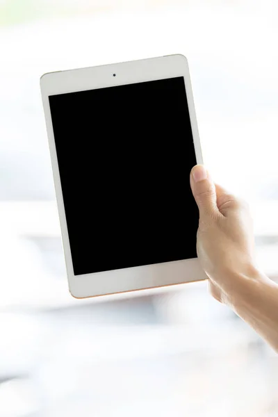 Frau hält weißes Tablet mit leerem Bildschirm in der Hand — Stockfoto