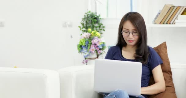 Молода Жінка Окулярах Сидить Дивані Використовуючи Ноутбук Вдома Живому Тлі — стокове відео