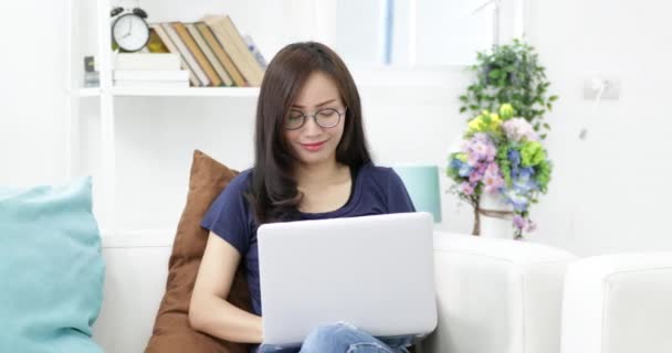 Νεαρή Γυναίκα Γυαλιά Κάθεται Στον Καναπέ Χρησιμοποιούν Φορητό Υπολογιστή Στο — Αρχείο Βίντεο