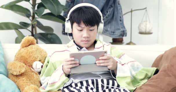 Jeune Asiatique Garçon Jouer Sur Tablette Avec Casque Maison — Video