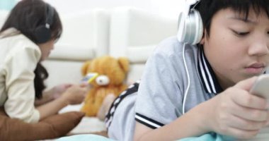 Rahatlatıcı ve genç çocuk oturma odasında tablet bilgisayarda oynama ile müzik Genç Asyalı kadın.