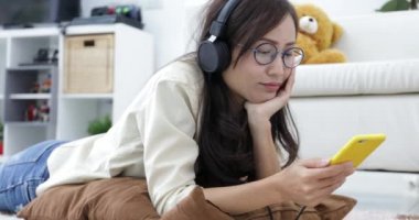 Rahatlatıcı ve genç çocuk oturma odasında tablet bilgisayarda oynama ile müzik Genç Asyalı kadın.