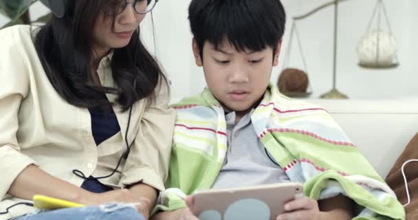 Mladá Asijská Žena Uvolňující Poslechu Hudby Mladým Chlapcem Tabletový Počítač — Stock video