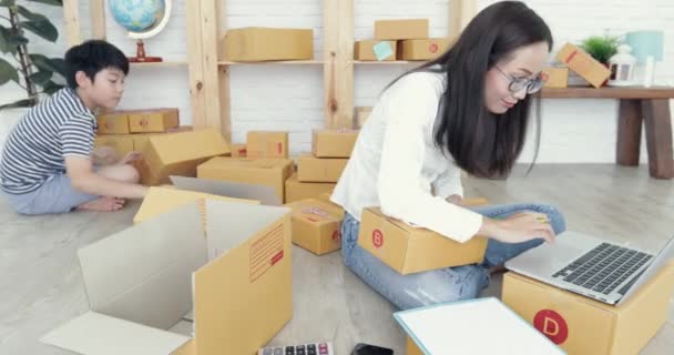年轻的亚洲妇女与儿童男孩工作和包装泰国邮政信箱发送 年轻的企业启动 中小企业 交付项目 — 图库视频影像