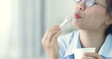 Mutlu Asyalı kız zevk gülümsemek yüz evde dondurma yeme.