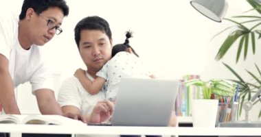 Asya modern aile ve küçük kız, baba evde çalışma masasında defter ile office çalışsa da. Beyaz.