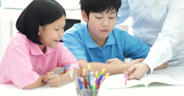 Unga Asiatiska Lärare Hjälper Unga Skola Barnen Klassen Närbild — Stockvideo