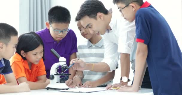 Professeur Asiatique Étendant Étudiant Classe Biologie Avec Microscope — Video