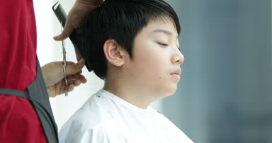 Bir saç kesimi saç kesme makineleri ile sahip bir çocuk