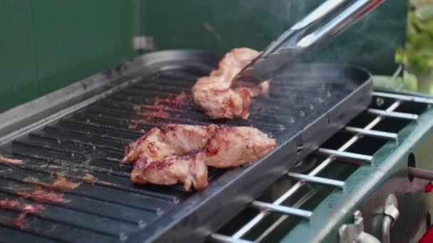 肉のショットを閉じます 調理中にバーガーをひっくり返す 男はバーベキューで肉を調理 調理されている肉の下から発生する炎 — ストック動画