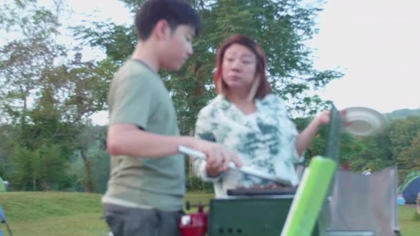 Asiatiska Mor Och Son Ska Grilla Till Middag Medan Campar — Stockvideo