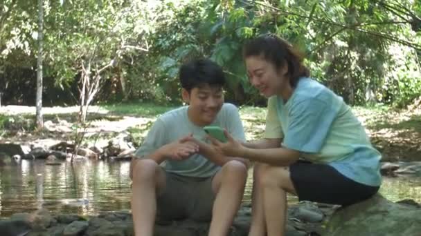 Asiática Madre Hijo Utilizando Teléfono Móvil Mientras Descansa Durante Paseo — Vídeos de Stock