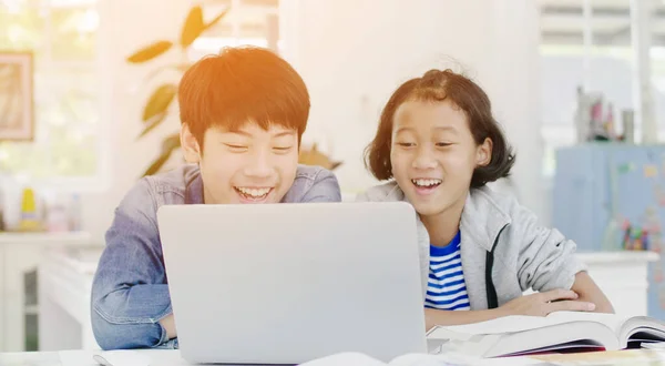 Jovem asiático menino e menina jogando com laptop computador em casa . — Fotografia de Stock