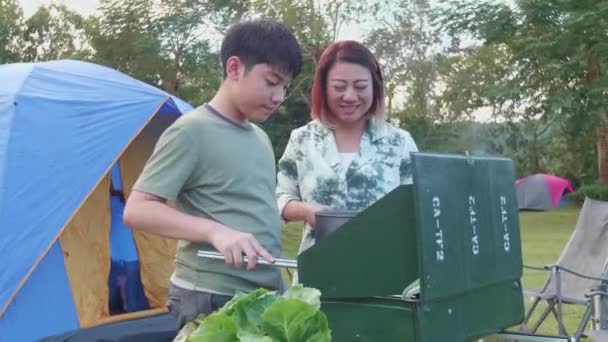 Aasialainen Äiti Poika Grillaavat Päivälliseksi Menossa Telttailemaan Iloisesti — kuvapankkivideo