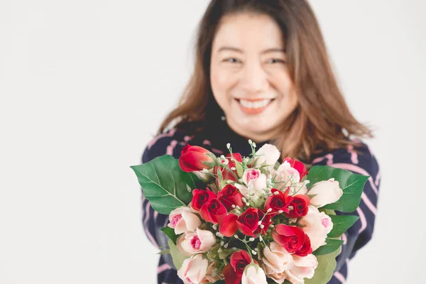 Asiatico sorridente donna su grigio studio colpo con rosso rosa fiore . — Foto Stock
